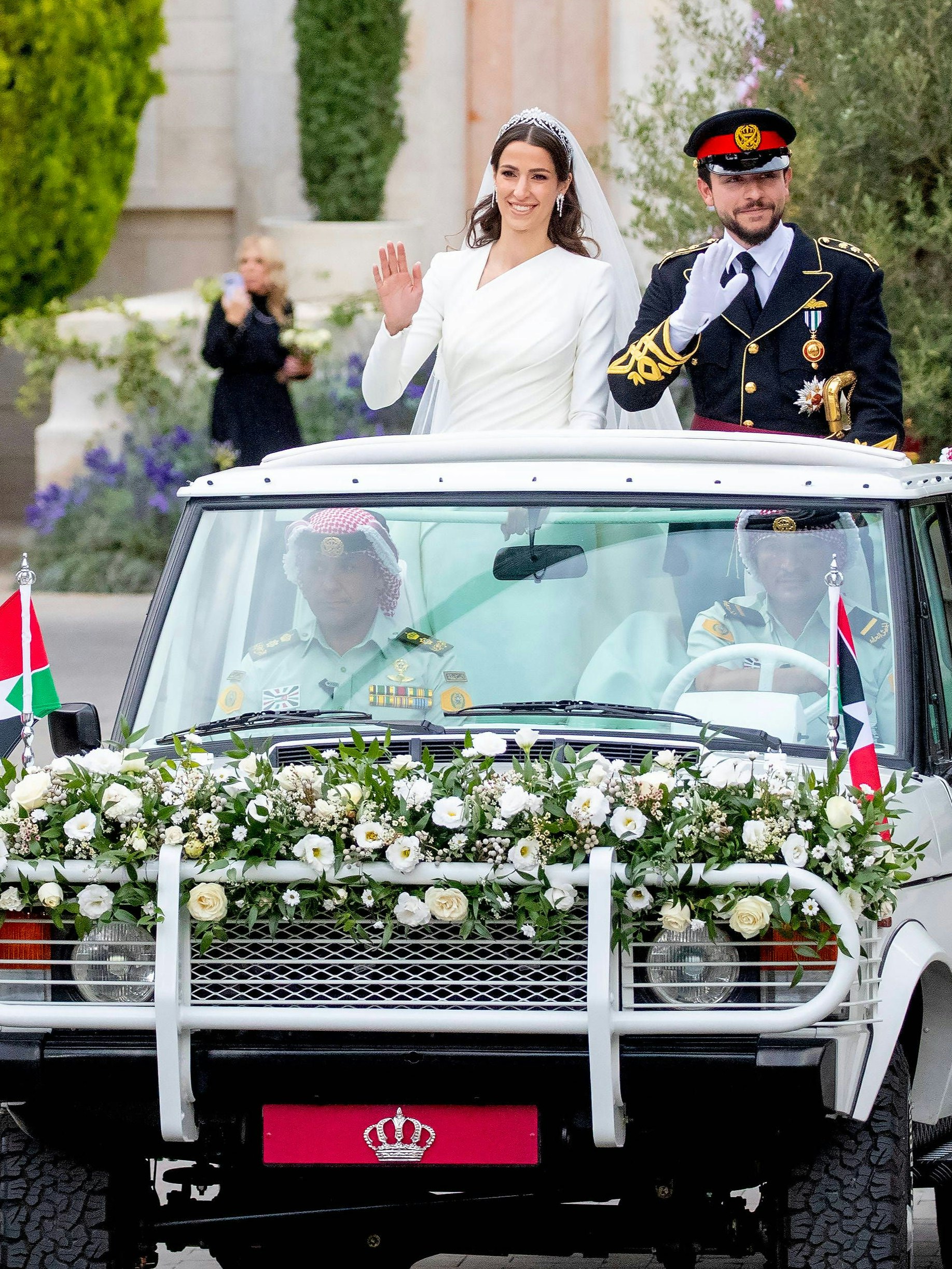 Der jordanische Kronprinz Hussein und die saudi-arabische Rajwa Al Saifwinken am Donnerstag, 1. Juni 2023, während ihrer Hochzeitszeremonie in Amman, Jordanien, den Gratulanten zu.