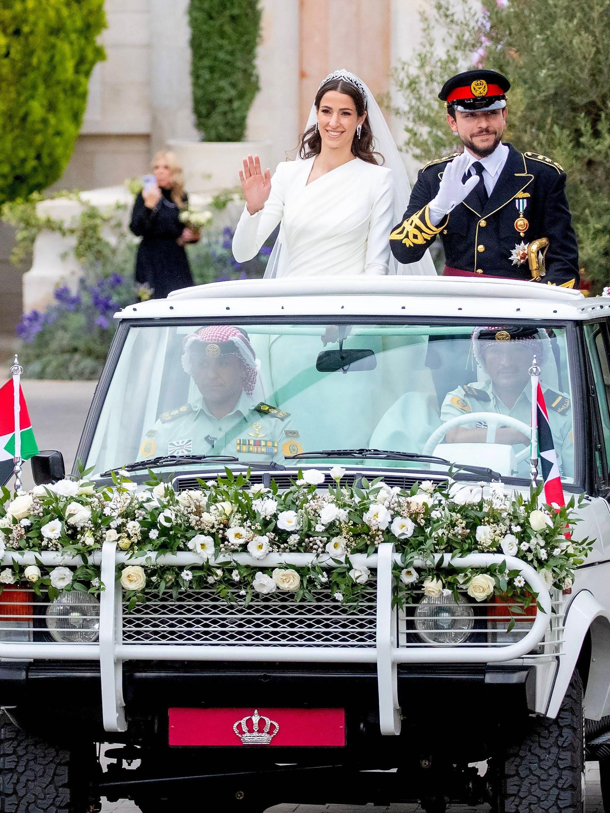 Der jordanische Kronprinz Hussein und die saudi-arabische Rajwa Al Saifwinken am Donnerstag, 1. Juni 2023, während ihrer Hochzeitszeremonie in Amman, Jordanien, den Gratulanten zu.