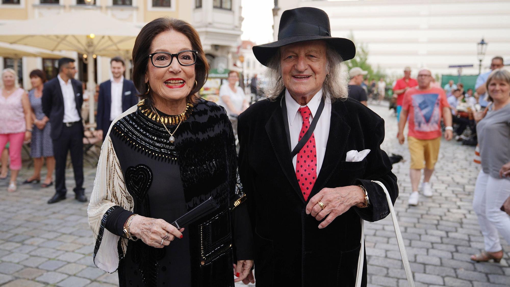 Nana Mouskouri und ihr Ehemann André Chapelle auf der Straße. Beide lächeln.