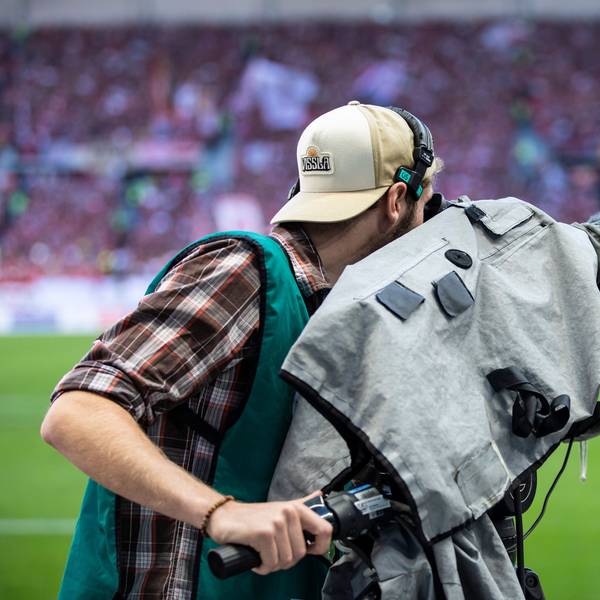 Ein Kameramann filmt vor einem Fußballspiel. (Symbolbild)