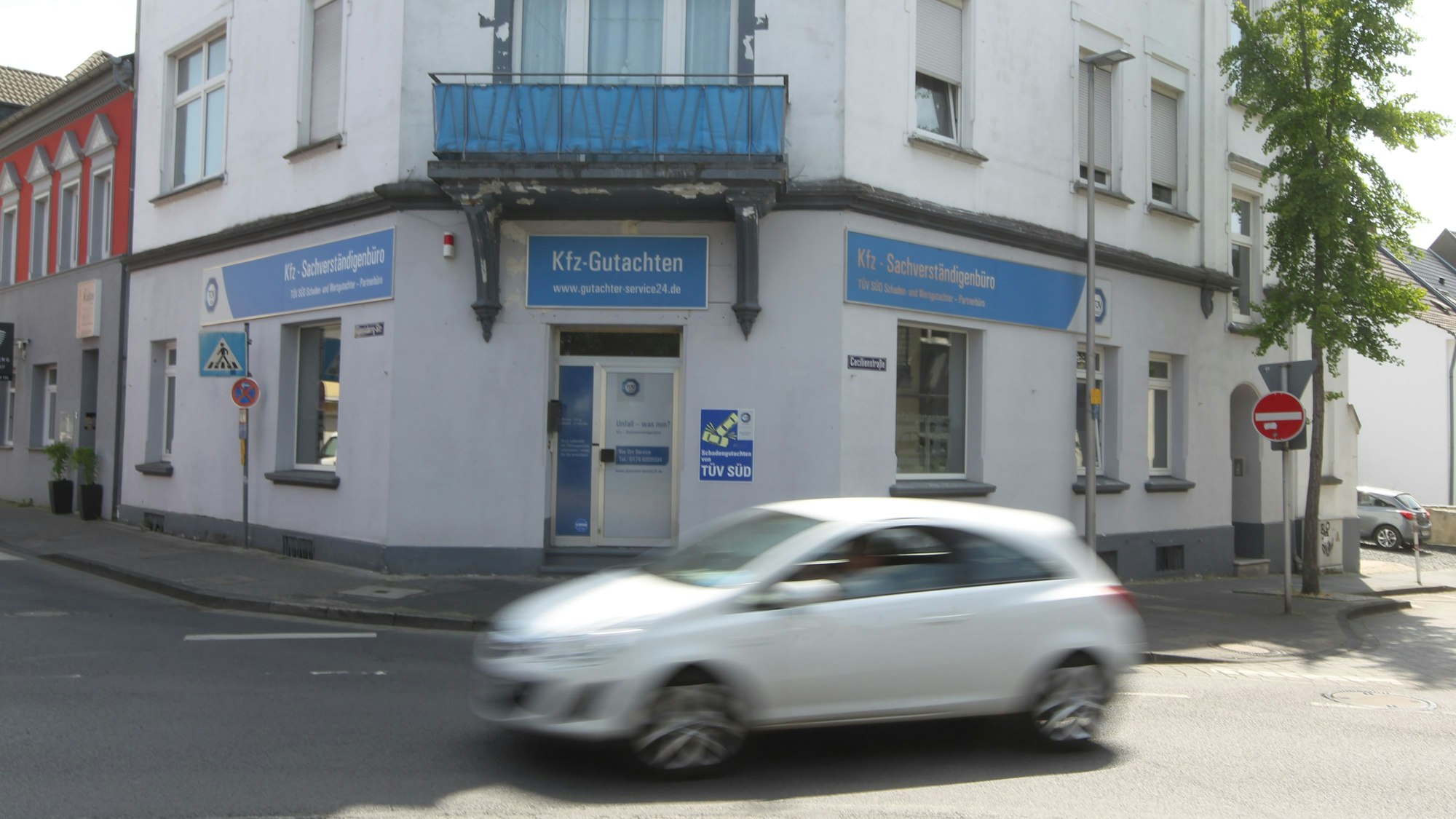 Ein Auto passiert ein Geschäftsgebäude.