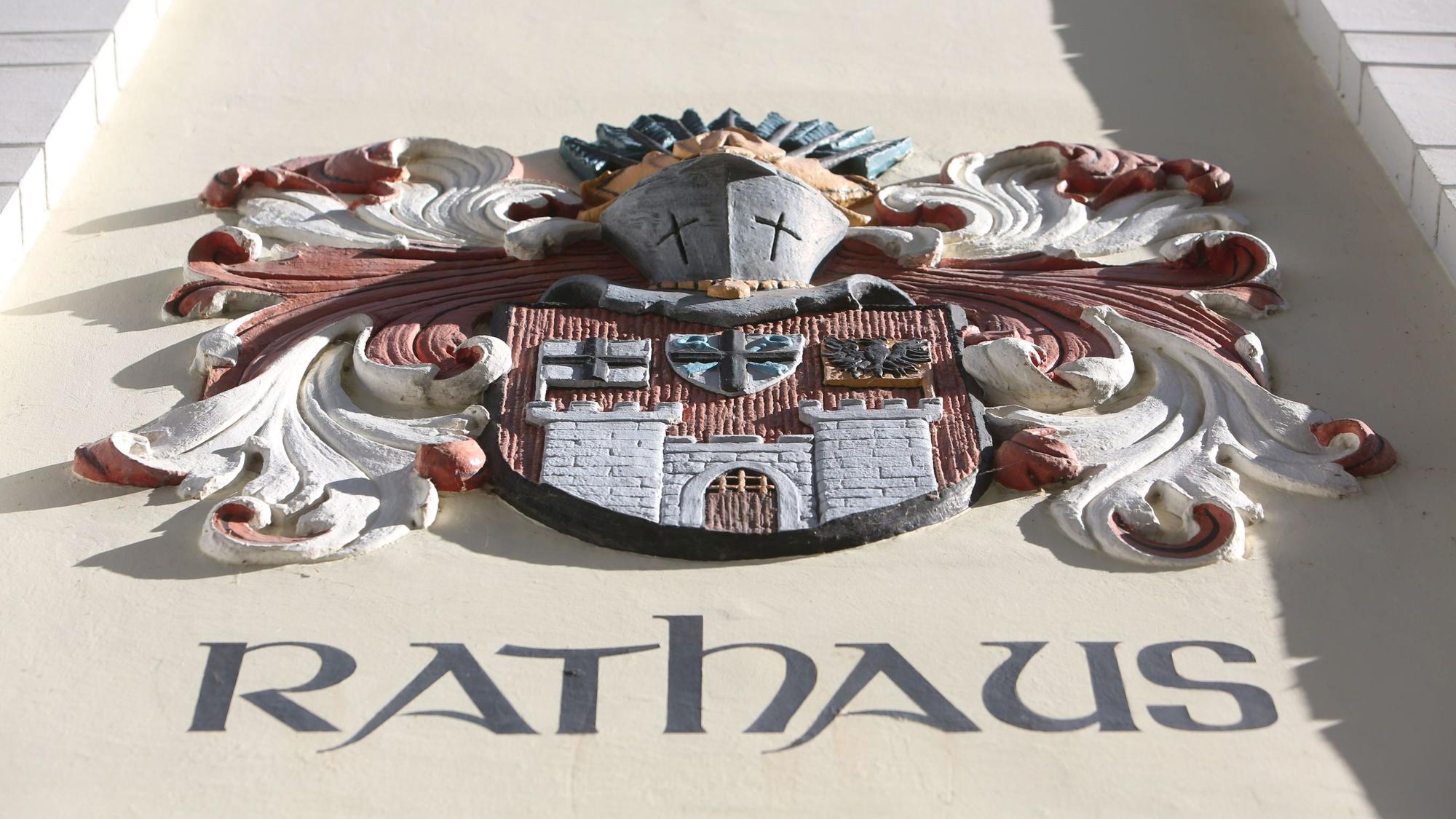 Der Schriftzug Rathaus steht unter einer Darstellung des alten Stadtwappens mit stilisiertem Ritterhelm.