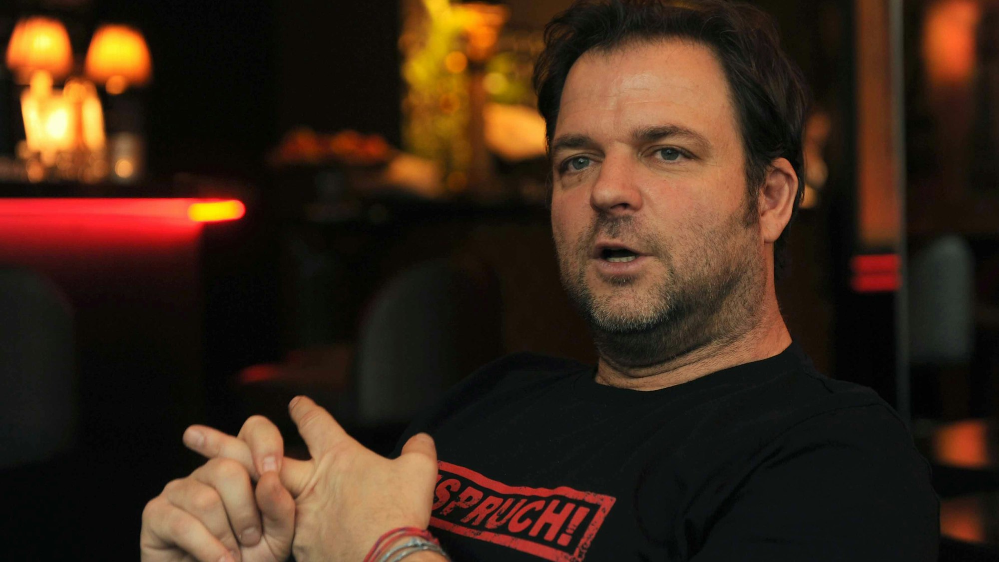 Martin Rütter, Hundelehrer, gestikuliert und schaut an der Kamera vorbei.