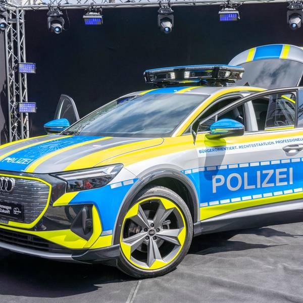 Ein Auto von Audi ist zu sehen mit besonders grelle, gelben Neonstreifen ringsum. Auf blauem Grund ist der Schriftzug Polizei zu lesen.