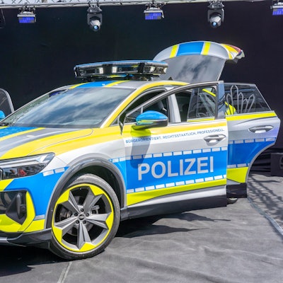 Ein Auto von Audi ist zu sehen mit besonders grelle, gelben Neonstreifen ringsum. Auf blauem Grund ist der Schriftzug Polizei zu lesen.