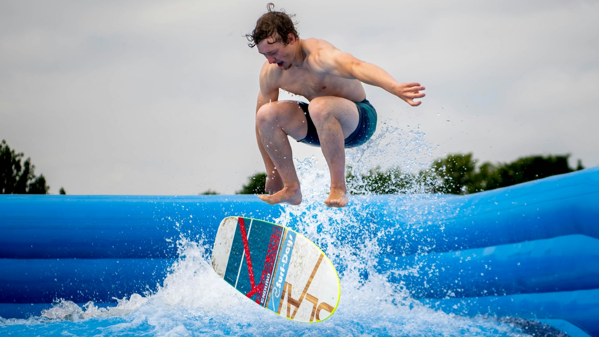Ein Profi, der das Brett fliegen lässt: Surflehrer Kai Scharrenbroich bringt den Anfängern in der Therme und Badewelt bis zum 23. Juli das Wellenreiten bei.