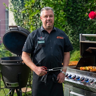 Grillkönig Michael Hoffmann steht am Grill in seinem Garten in Rösrath.