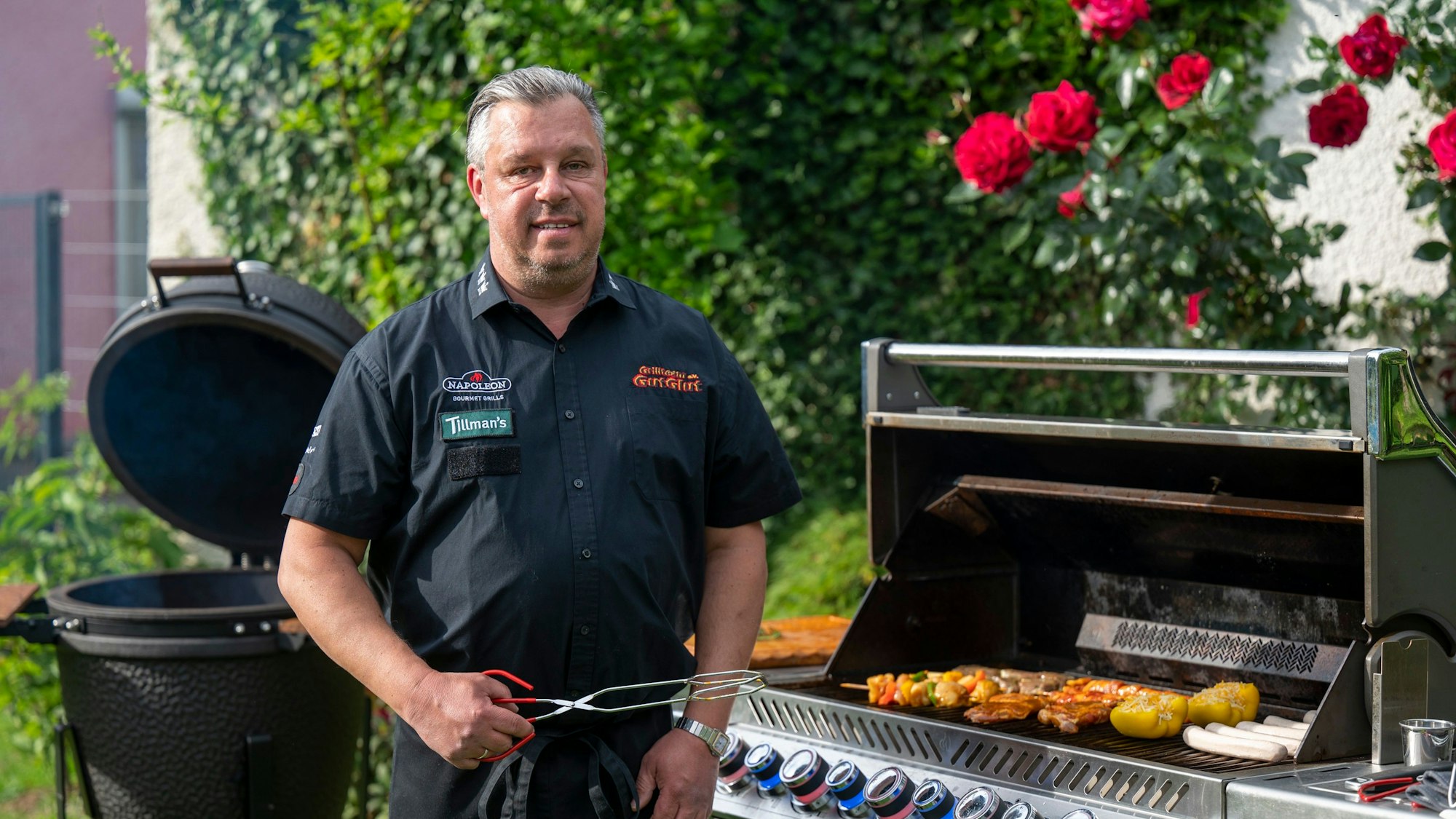 Grillkönig Michael Hoffmann steht am Grill in seinem Garten in Rösrath.