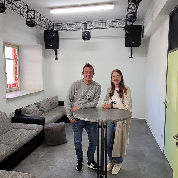 Ein Mann und eine Frau stehen an einem Stehtisch.