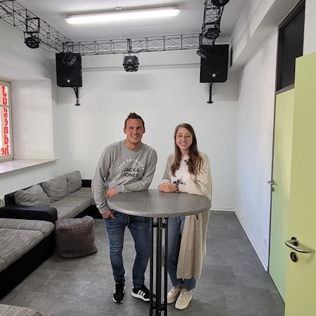 Ein Mann und eine Frau stehen an einem Stehtisch.