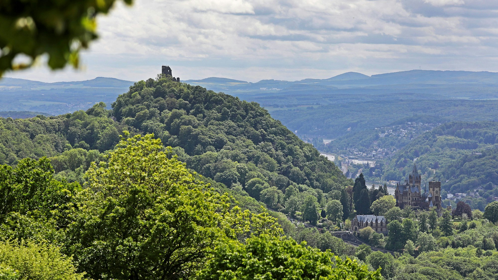 Schloss Drachenburg (r) und Burg Drachenfels sind oberhalb des Rheintals bei Königswinter vom Petersberg aus zu sehen.