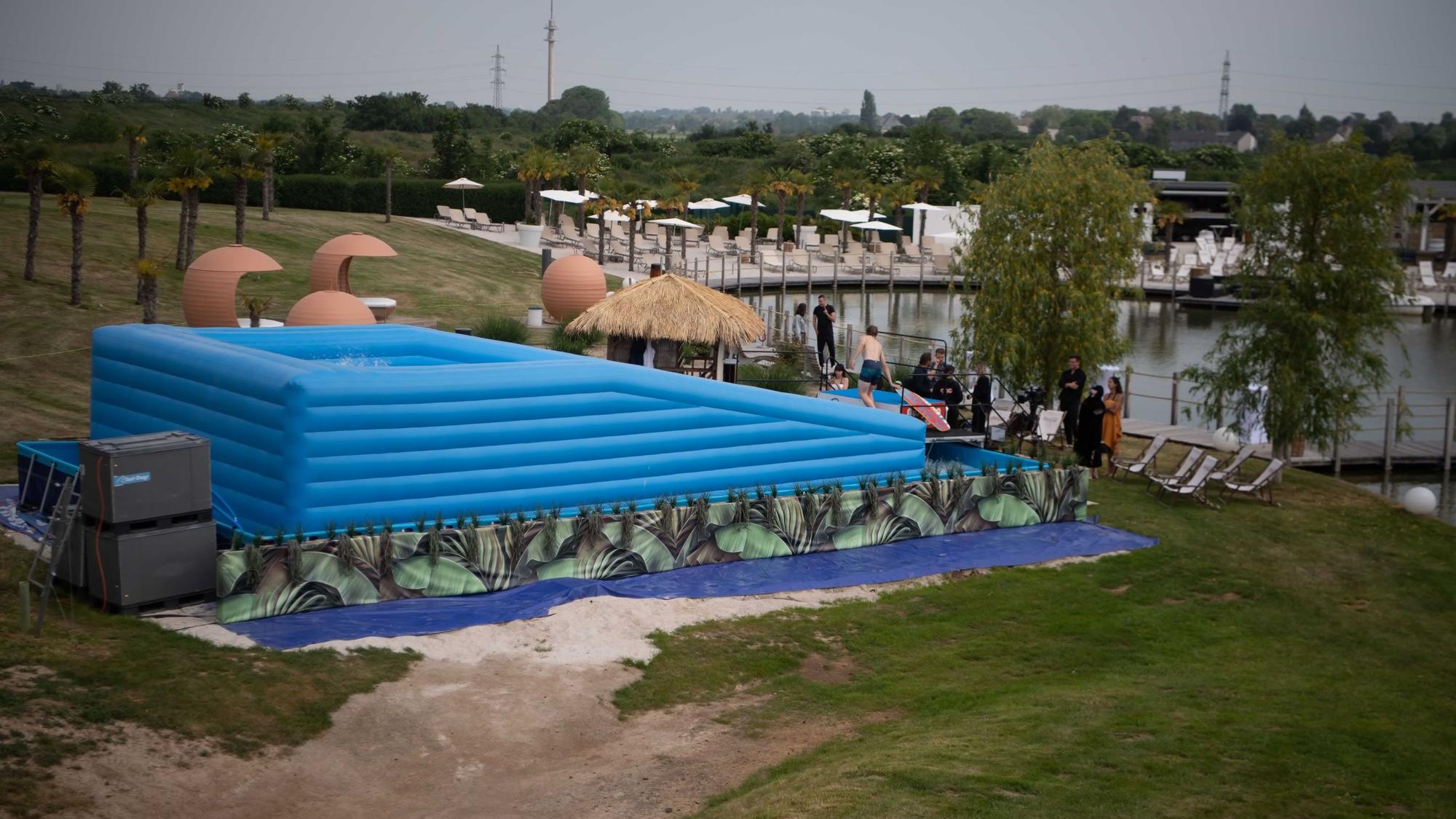 Die aufblasbare, hellblaue Surfstation vom Hügel der Therme aus ist zu sehen.