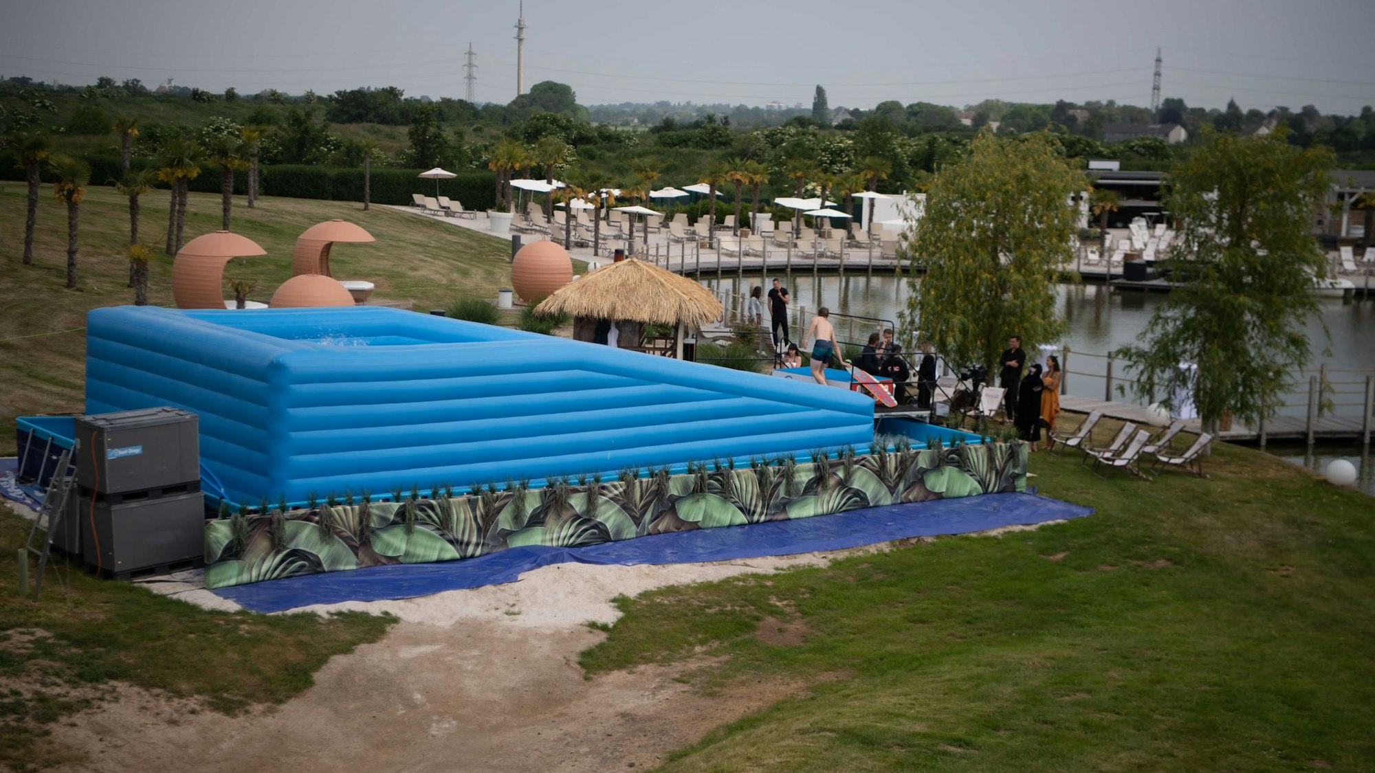 Die aufblasbare, hellblaue Surfstation vom Hügel der Therme aus ist zu sehen.