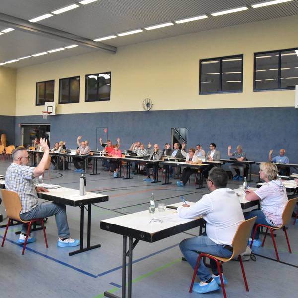 Der Gemeinderat Ruppichteroth bei einer Abstimmung in einer Sporthalle.