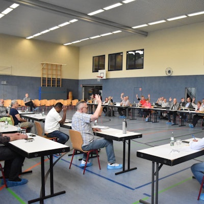 Der Gemeinderat Ruppichteroth bei einer Abstimmung in einer Sporthalle.