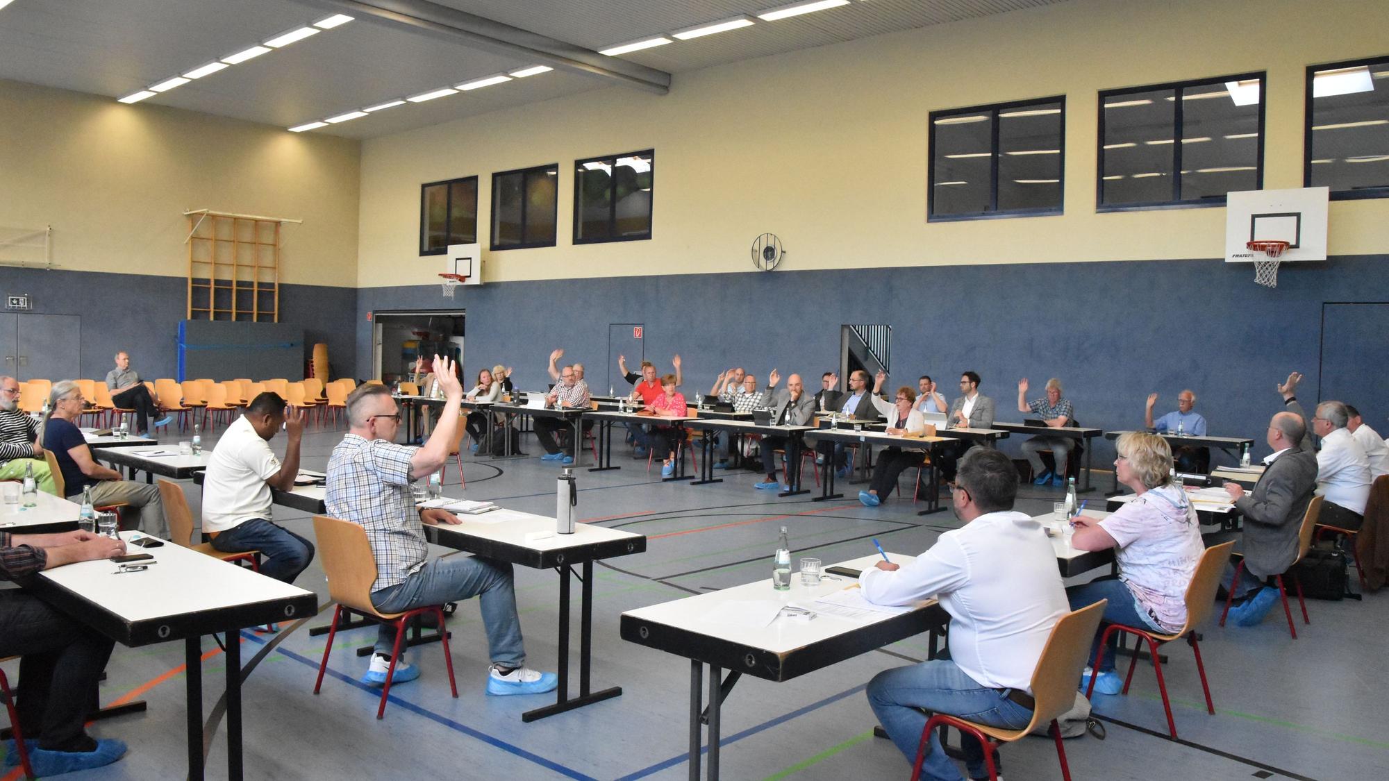 Der Gemeinderat Ruppichteroth bei einer Abstimmung in einer Sporthalle.