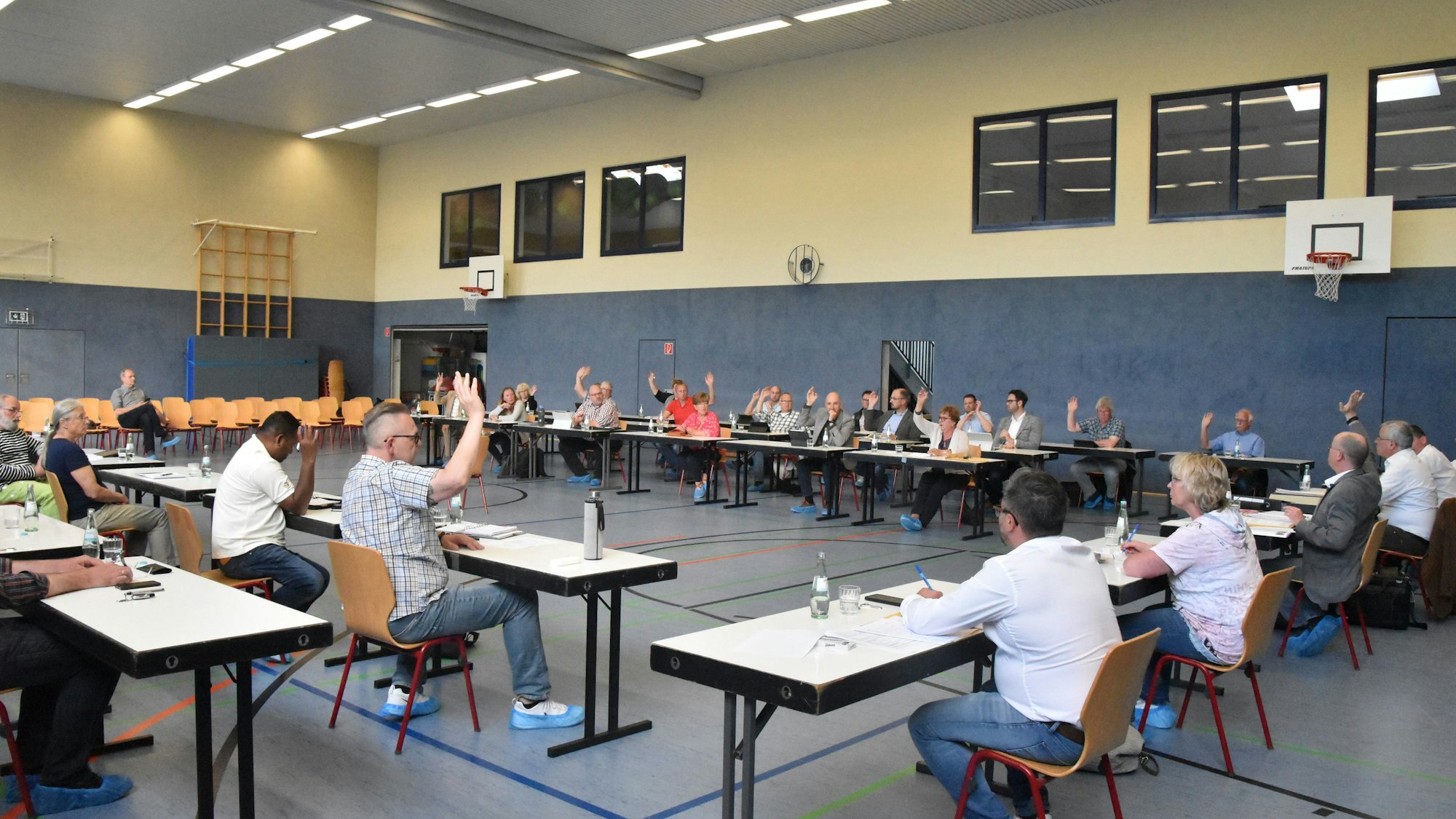 Der Gemeinderat Ruppichteroth bei einer Abstimmung in einer Sporthalle.