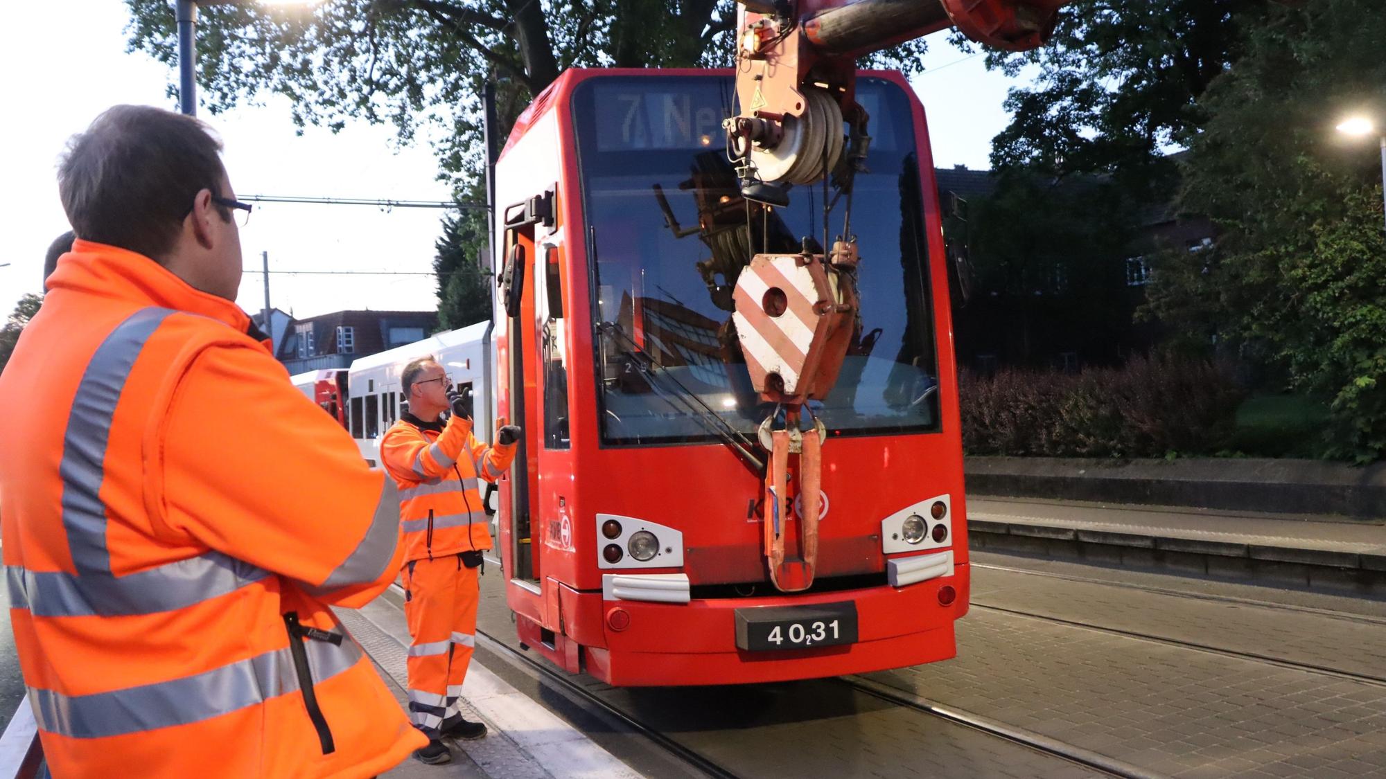 Es ist zu sehen wie die Straßenbahn durch den Kran angehoben wird.