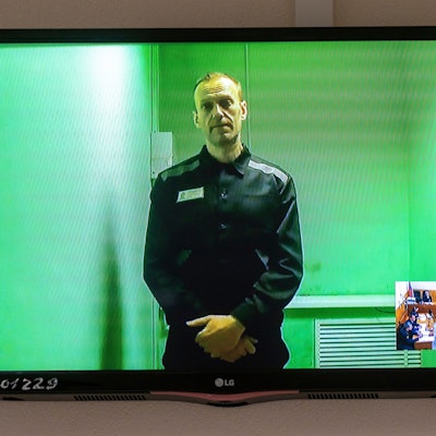 Der russische Oppositionsführer Alexej Nawalny spricht in einer von der russischen Strafvollzugsbehörde bereitgestellten Videoübertragung, aus dem Gefängnis. Ein Foto zeigt einen Fernsehbildschirm, auf dem er zu sehen ist.