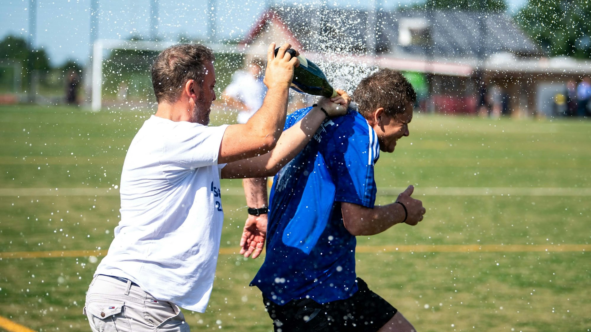 Die Sektdusche für Aufstiegstrainer Kevin Greuel gab es noch auf dem Platz.