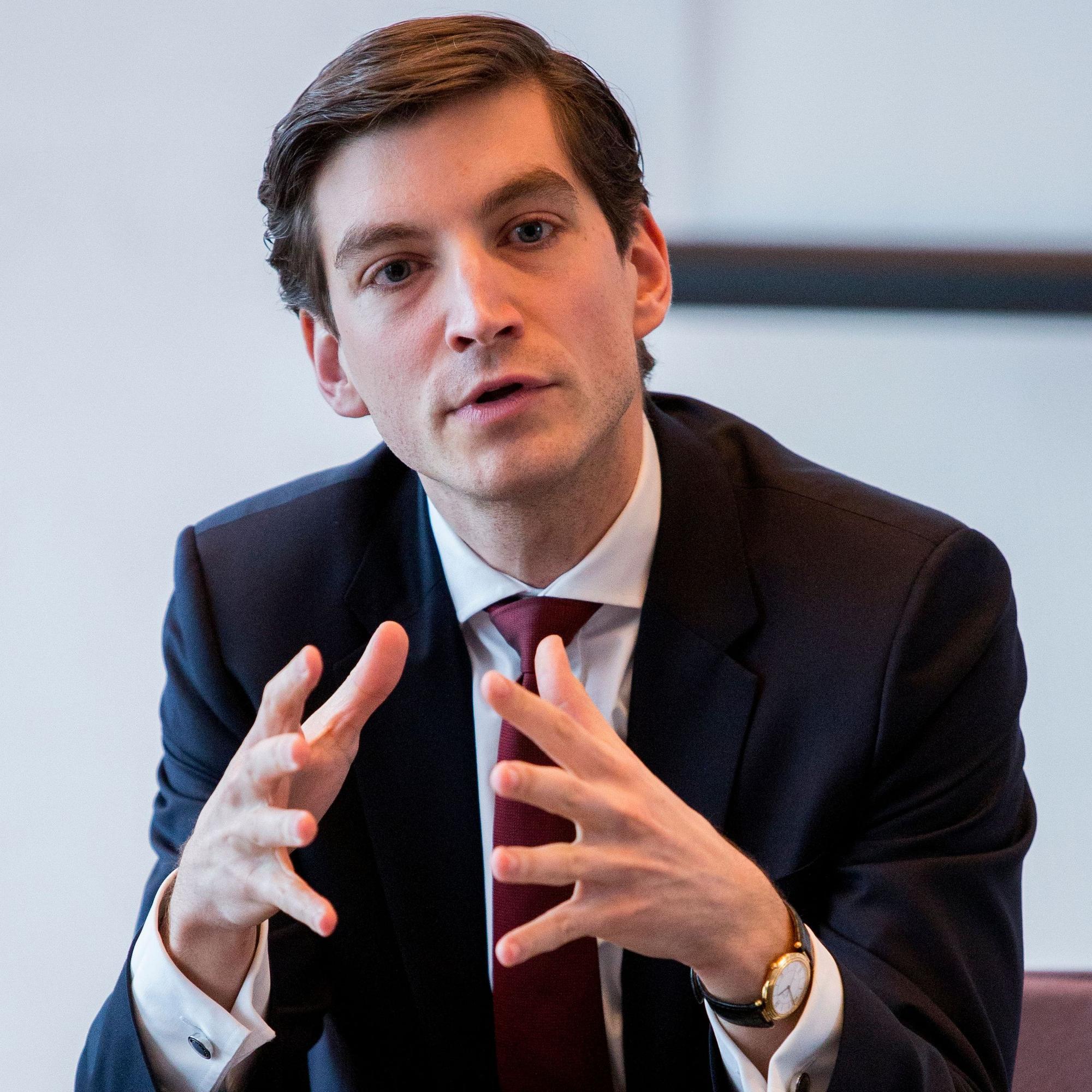 Alexander Vogel sitzt an einem Tisch.