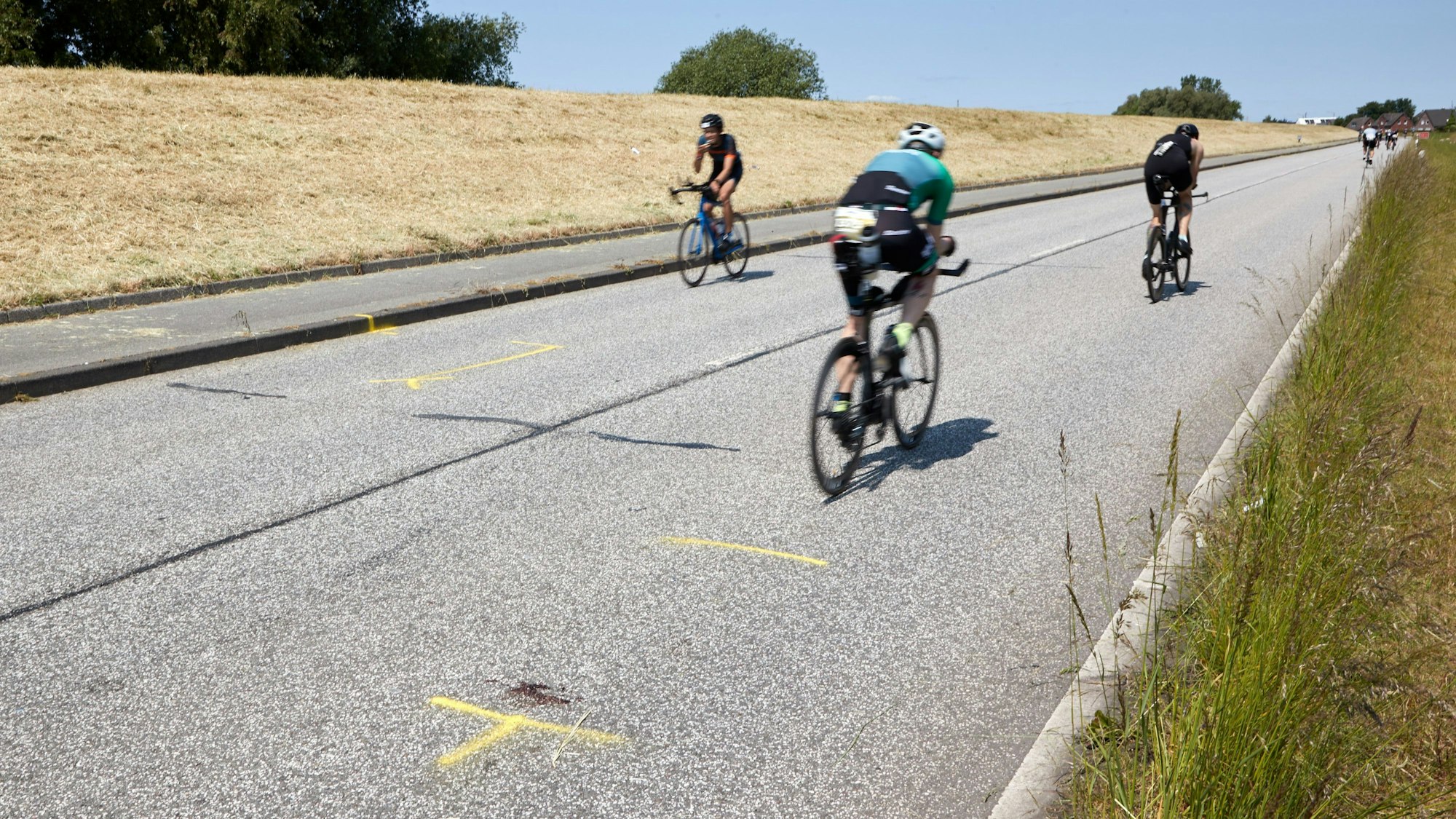 Tragödie in Hamburg: Teilnehmer der Ironman-EM fahren auf der Straße des Unfallorts, wo ein Motorradfahrer tödlich verunglückte.