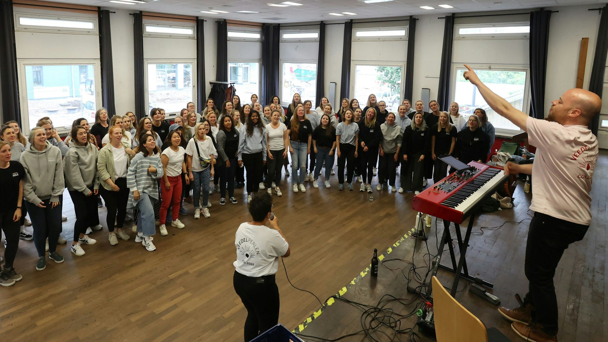 Der Chor steht im Halbkreis um den Chorleiter herum.