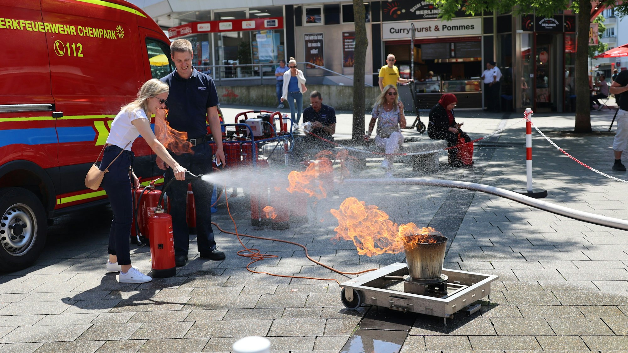 Eine Frau löscht mit einem Feuerlöscher einen künstlichen Brand