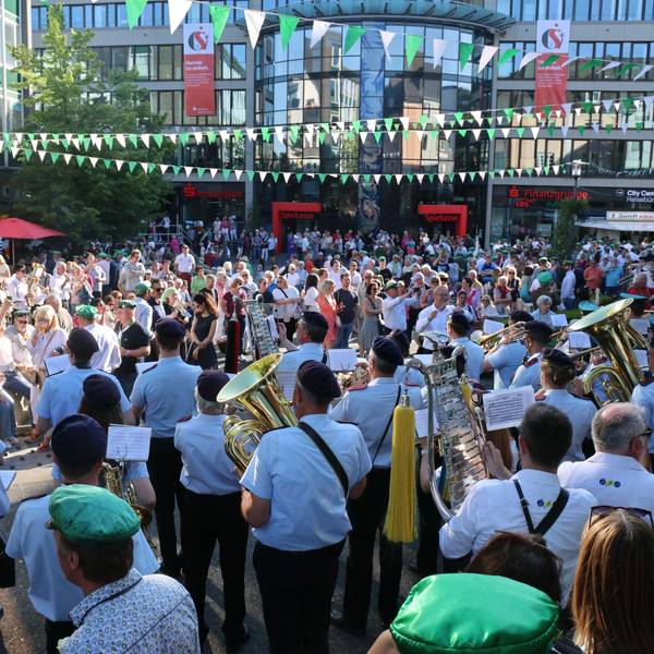 Auf dem Gummersbacher Lindenplatz stehen zahlreiche Menschen, darunter viele Musikvereine der jeweiligen Schützenvereine.