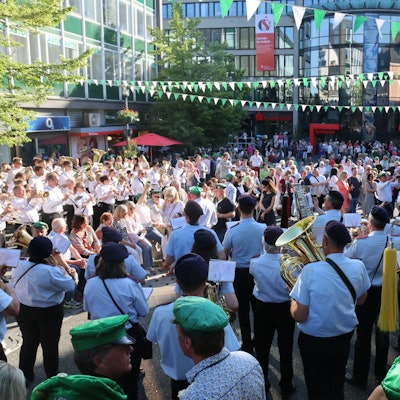 Auf dem Gummersbacher Lindenplatz stehen zahlreiche Menschen, darunter viele Musikvereine der jeweiligen Schützenvereine.