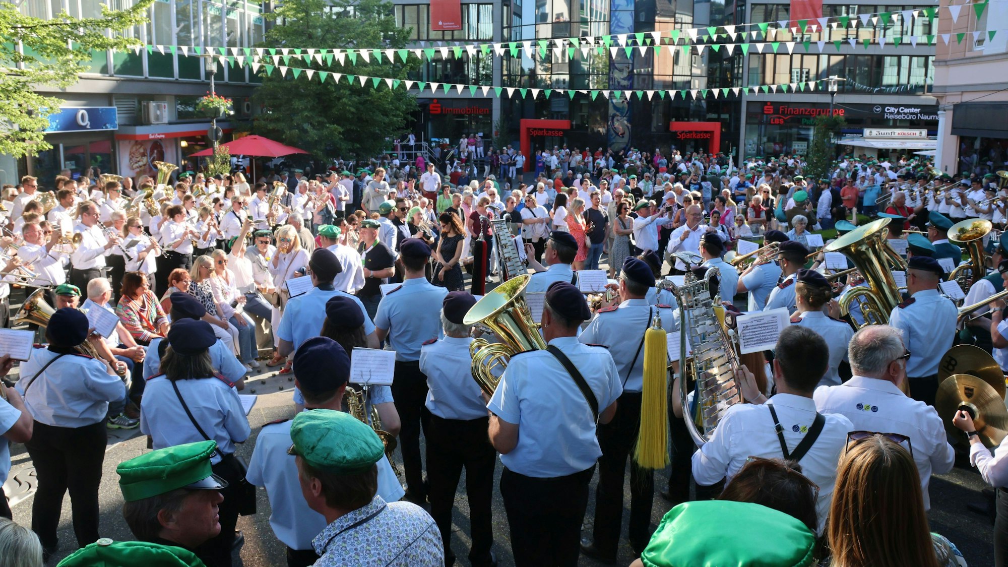 Auf dem Gummersbacher Lindenplatz stehen zahlreiche Menschen, darunter viele Musikvereine der jeweiligen Schützenvereine.