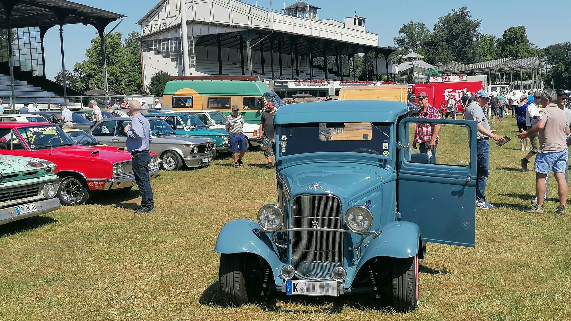 Ein Oldtimer steht auf der Galopprennbahn.