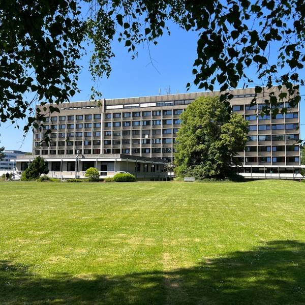 Das Krankenhaus Porz von hinten mit einer grünen Wiese im Vordergrund.