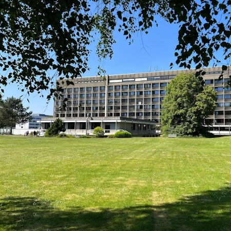 Das Krankenhaus Porz von hinten mit einer grünen Wiese im Vordergrund.