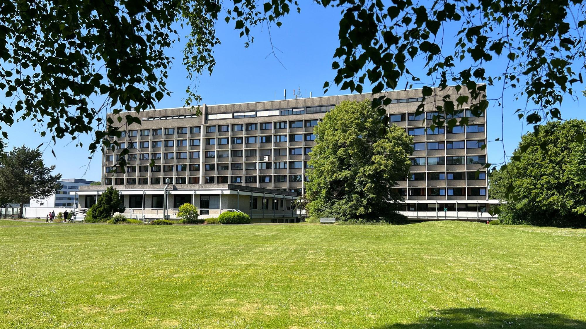 Das Krankenhaus Porz von hinten mit einer grünen Wiese im Vordergrund.