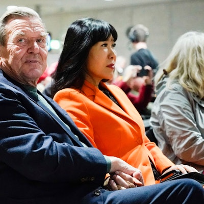 Der ehemalige Bundeskanzler Gerhard Schröder und seine Frau So-yeon Schröder-Kim sitzen bei einer Veranstaltung.