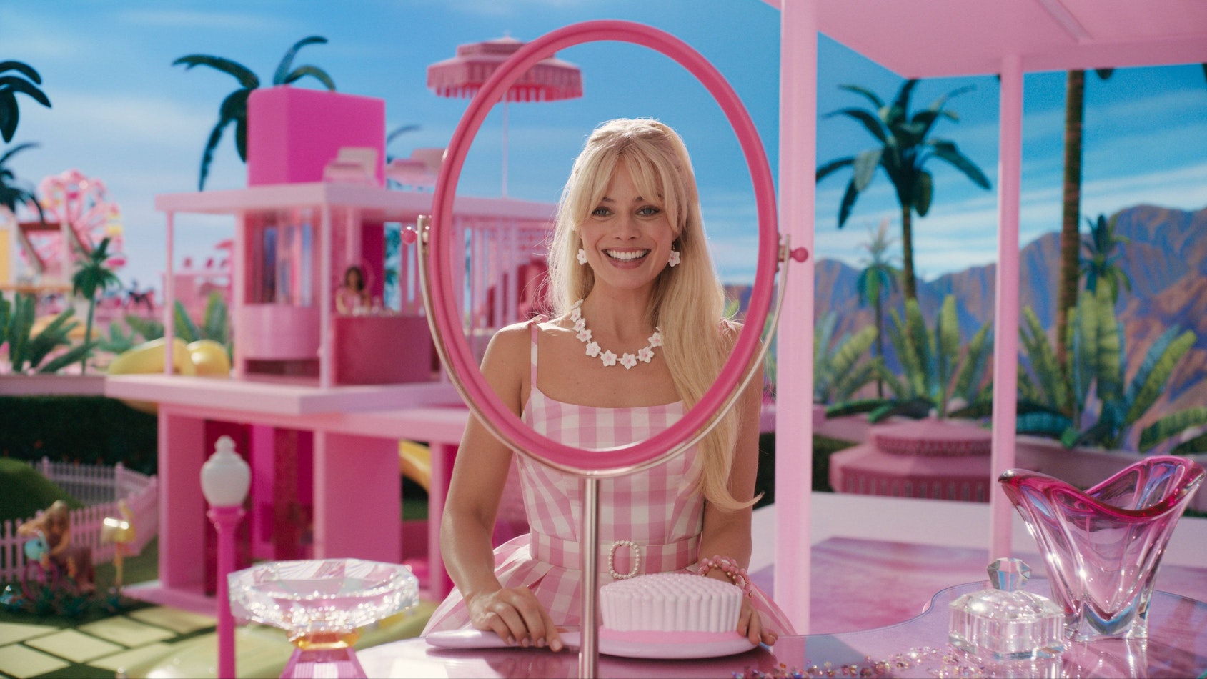 Szene aus dem „Barbie“-Film: Margot Robbie als Barbie in ihrem Traumhaus vor einem Spiegel.