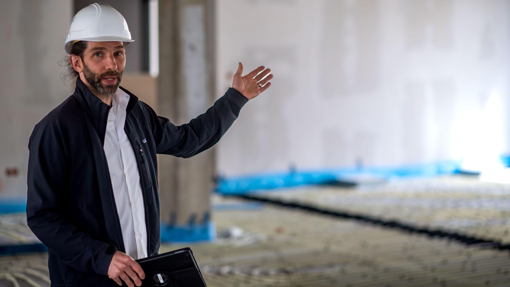 Thilo Lenhard steht in der Baustelle des Kreishauses und deutet in den leeren Raum.