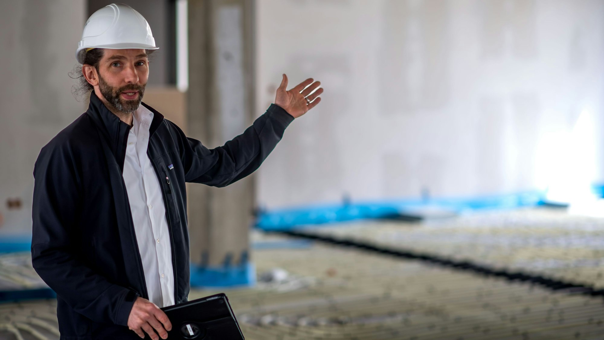 Thilo Lenhard steht in der Baustelle des Kreishauses und deutet in den leeren Raum.