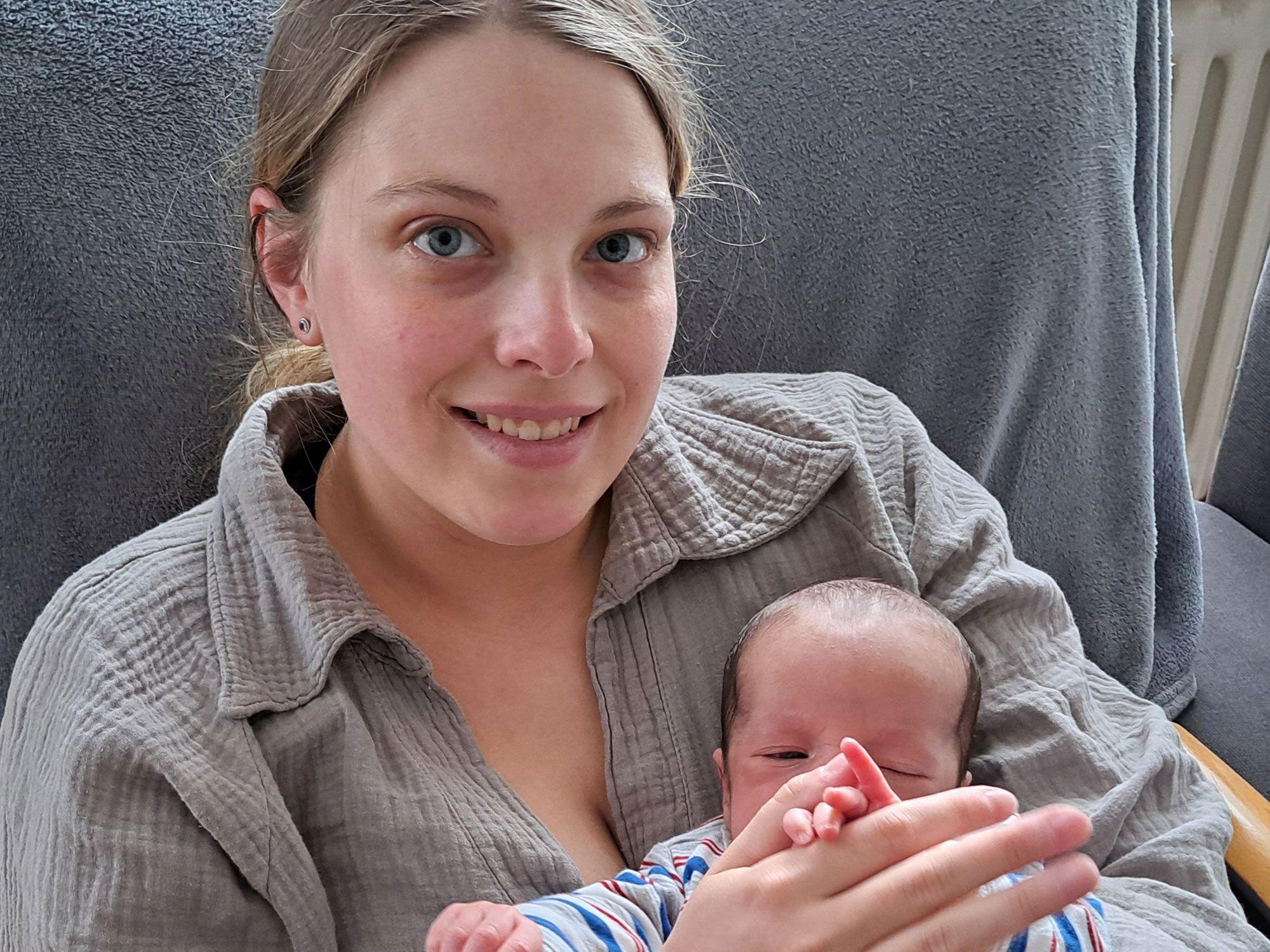 Eine junge Frau hält ein Baby auf dem Arm.