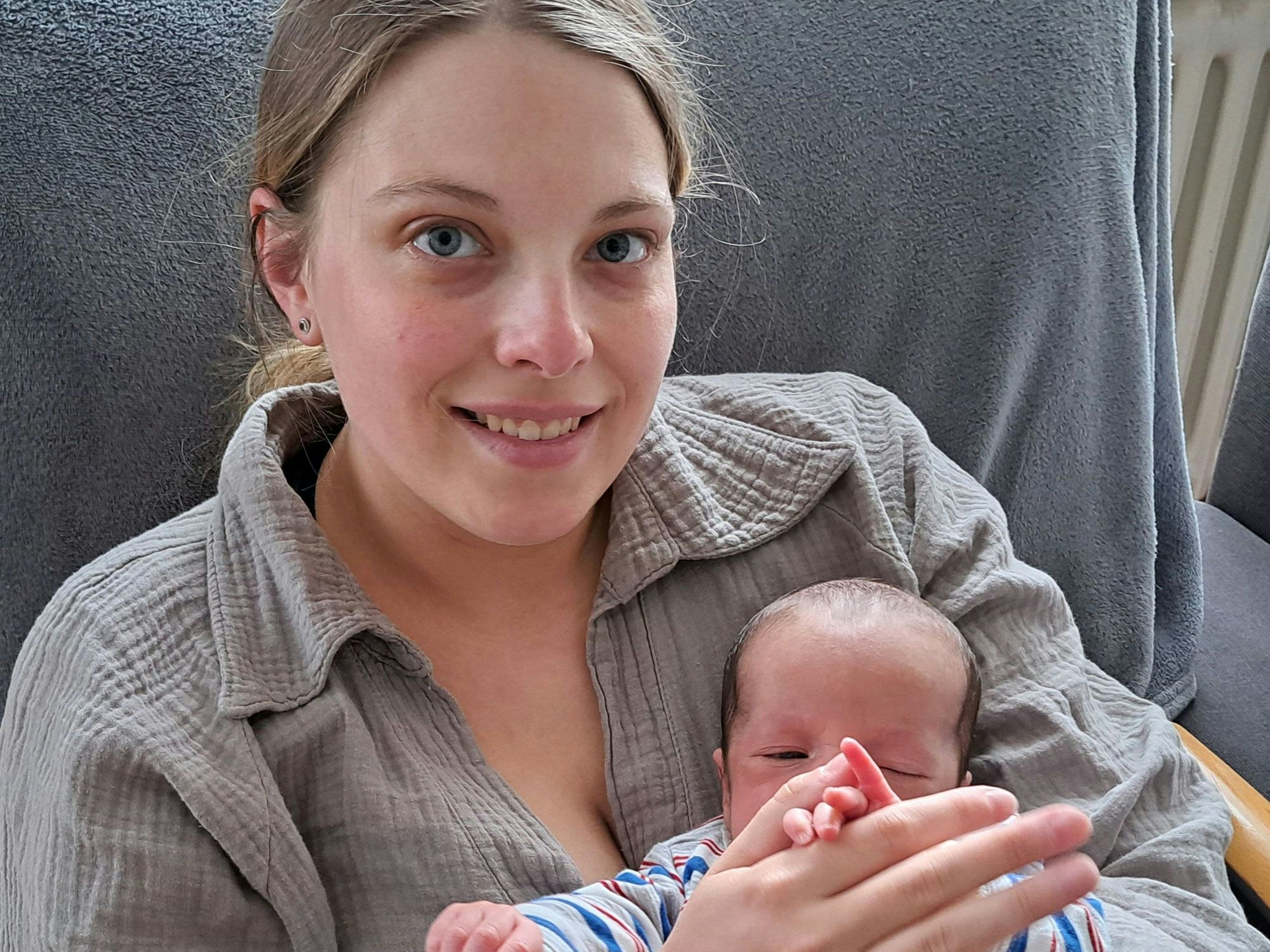 Eine junge Frau hält ein Baby auf dem Arm.