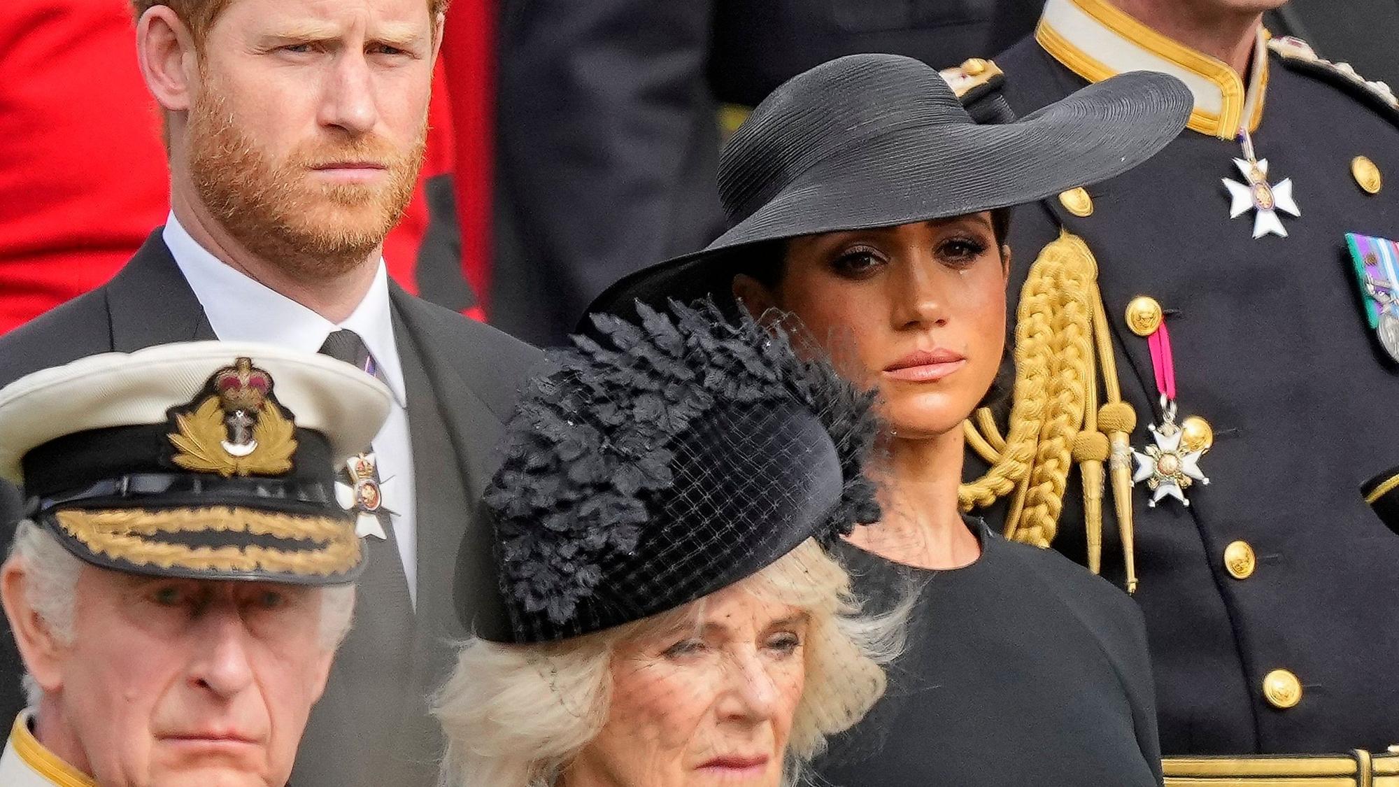 König Charles III. (vorn), Königsgemahlin Camilla, Prinz Harry, Herzog von Sussex, (dahinter), und seine Frau Meghan, Herzogin von Sussex, schauen auf den Trauerzug mit dem Sarg der gestorbenen britischen Königin.