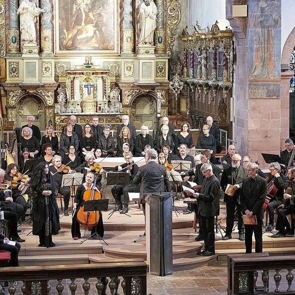 Ein Chor und ein Orchester musizieren im Altarraum der Steinfelder Basilika.