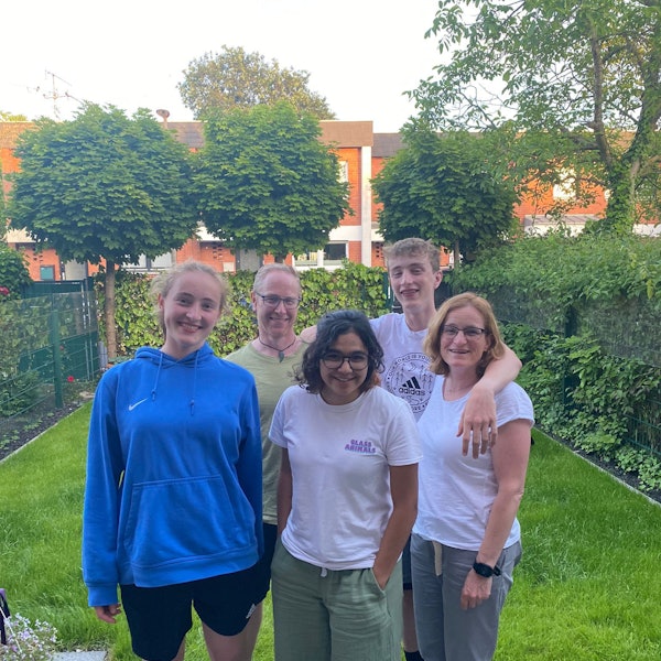 Eine Familie steht in ihrem Garten.