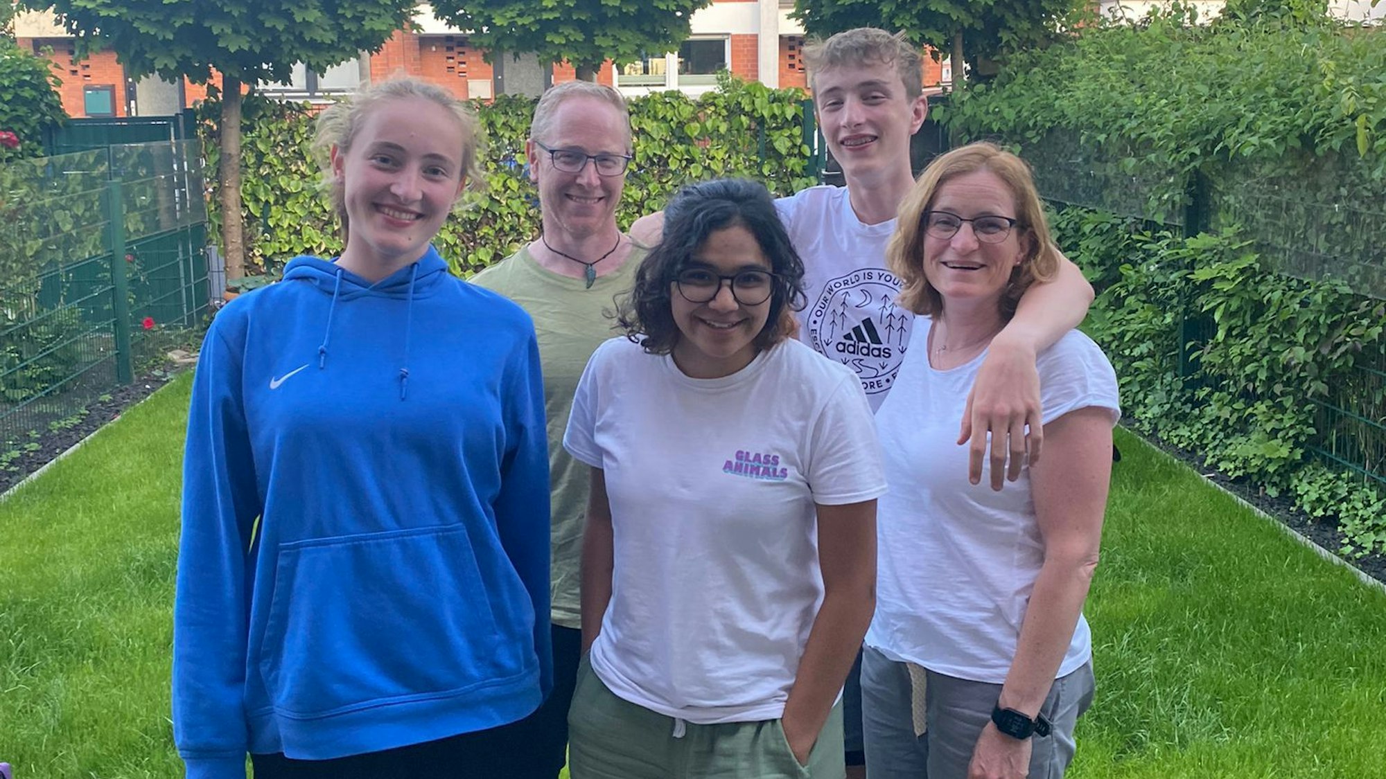 Eine Familie steht in ihrem Garten.