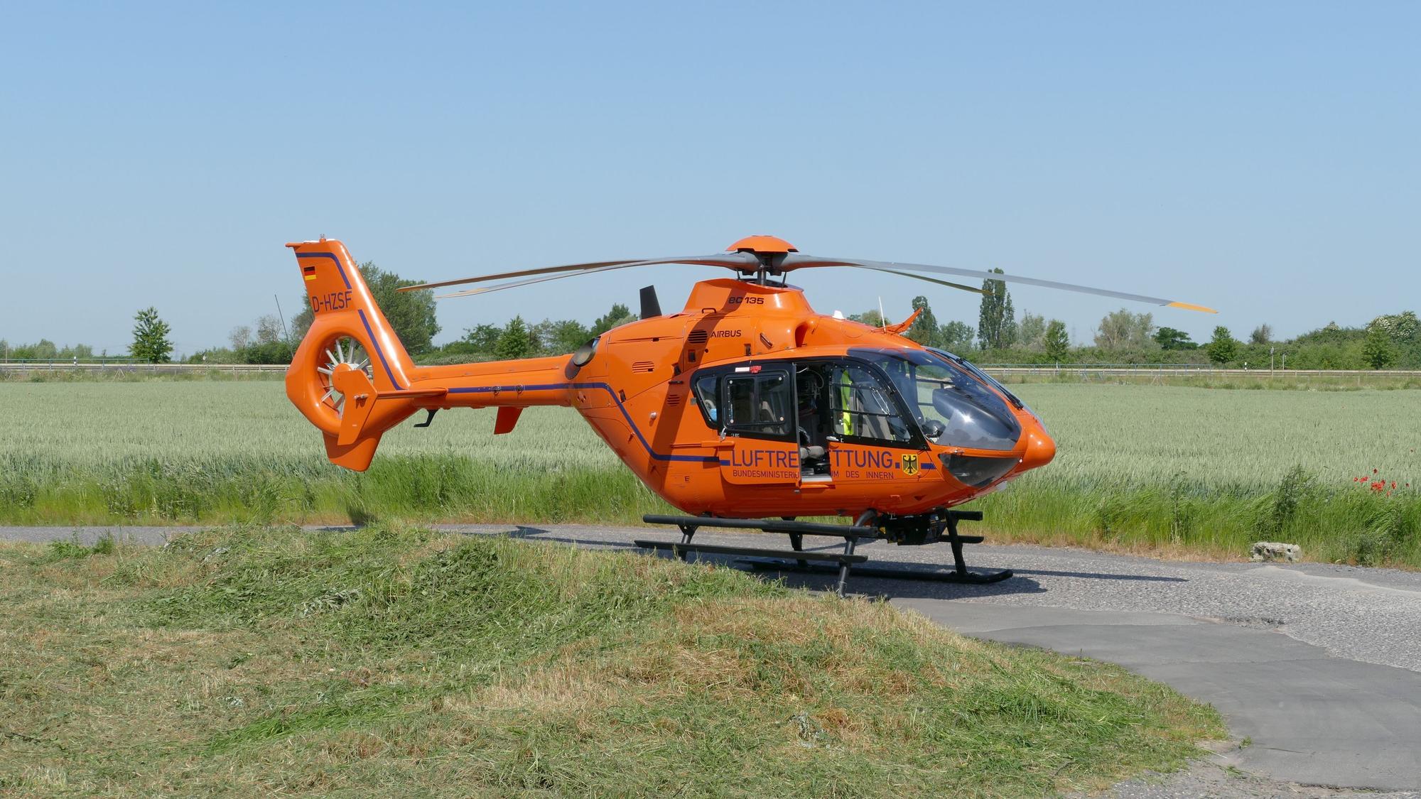 Ein Rettungshubschrauber steht auf einer Wiese.