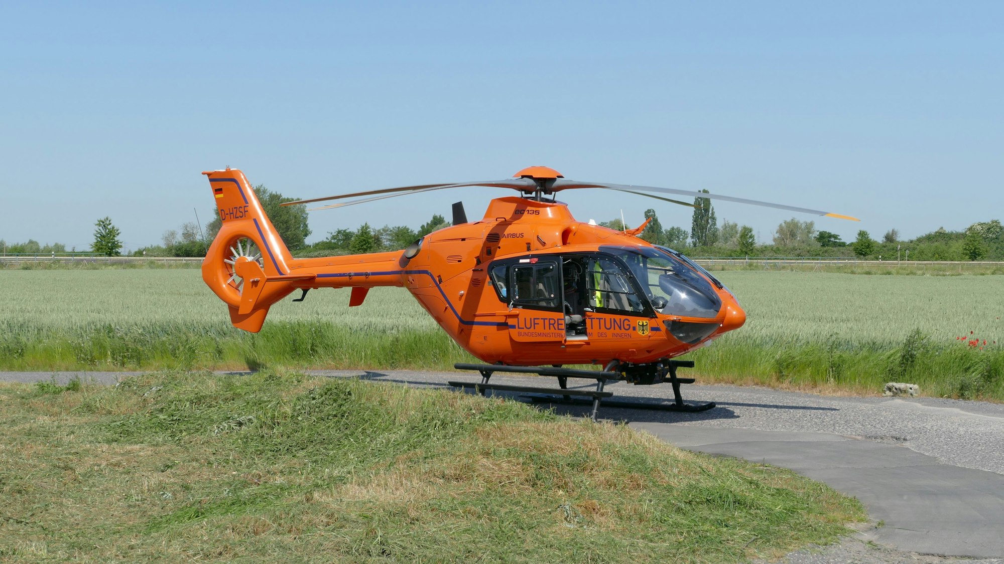 Ein Rettungshubschrauber steht auf einer Wiese.