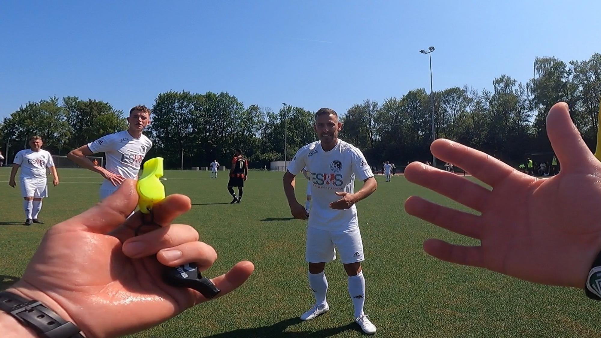 Schiedsrichter Daniel Emami gestikuliert nach einem Freistoßpfiff mit den Händen.