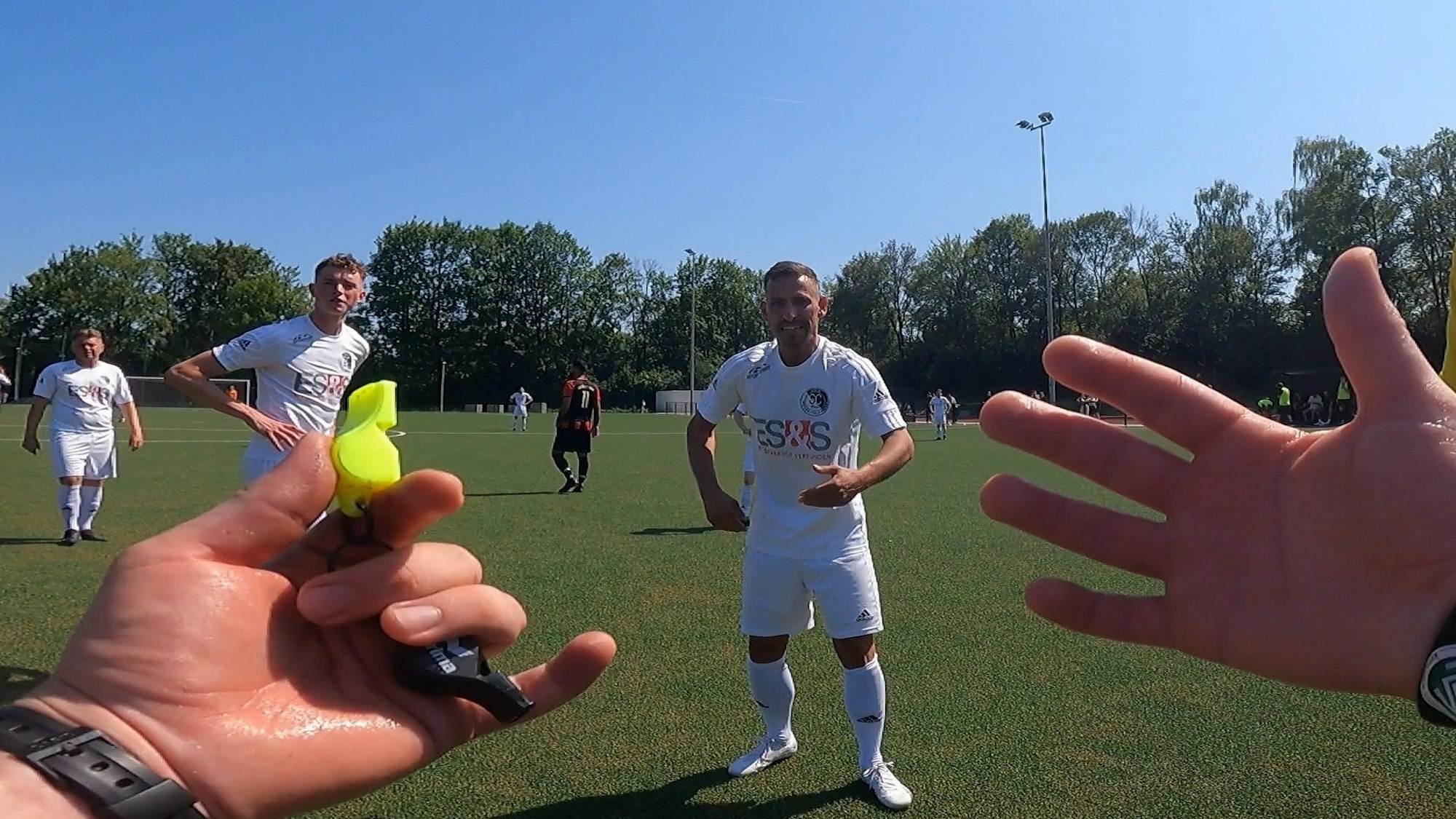 Schiedsrichter Daniel Emami gestikuliert nach einem Freistoßpfiff mit den Händen.