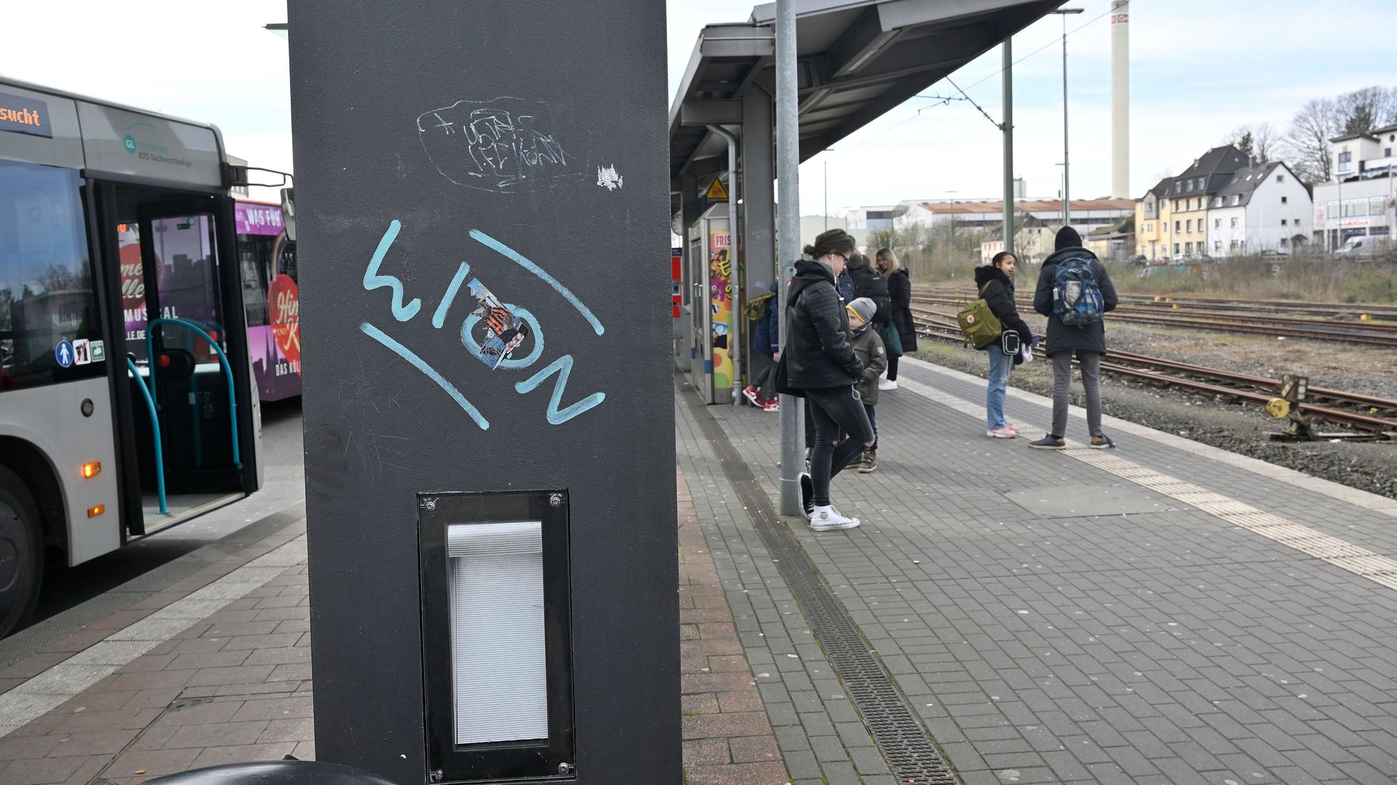 Menschen stehen am Bahnhof.